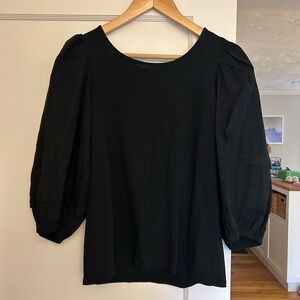 Black puff sleeve top with open back and bow.